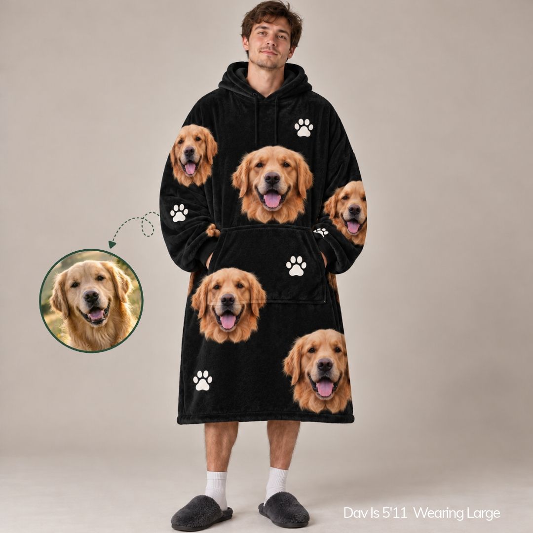 A man wearing a black hooded robe printed with multiple golden retriever faces and white paw prints, shown against a plain beige studio background. A circular inset highlights one of the dog faces, and text in the lower right reads 'Davi's 5'11 Wearing Large'.