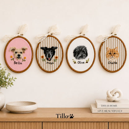 Four personalized pet portrait embroidery hoops displayed on a wall above a wooden console table. The hoops feature custom pet illustrations labeled Bella, Maya, Olive, and Charlie, each with a striped background and lace ribbon hangers.